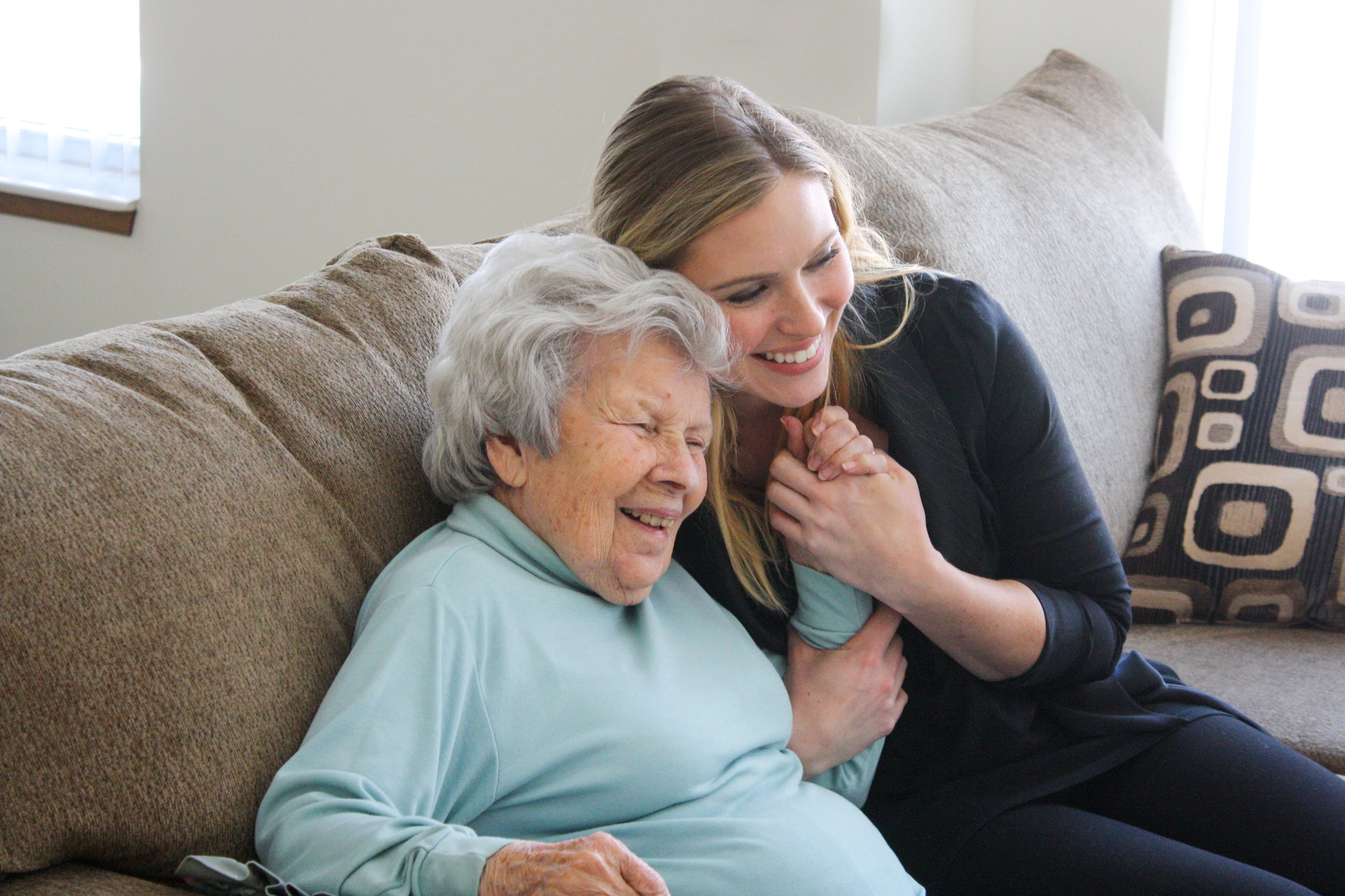 A Comfort Health caregiver sitting close with a longtime client, end of day.