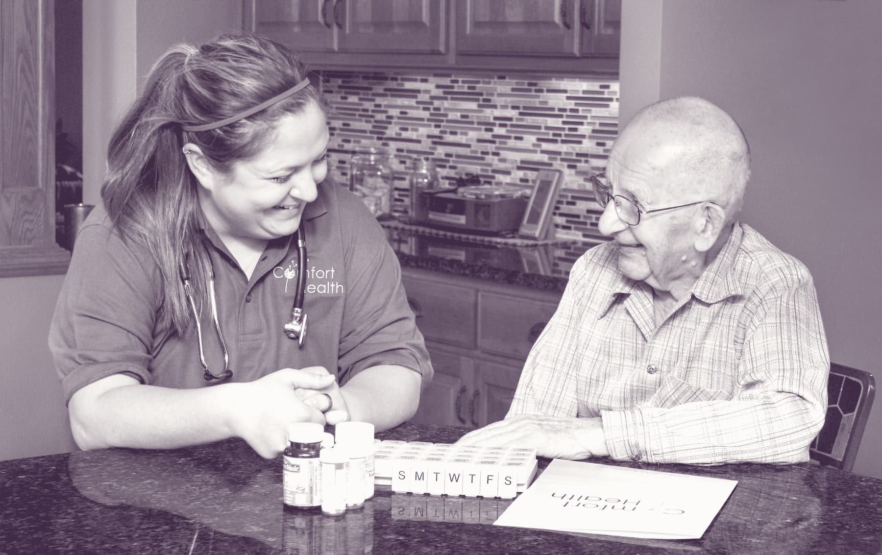 A Comfort Health nurse organizing a client's weekly medications at the kitchen table.