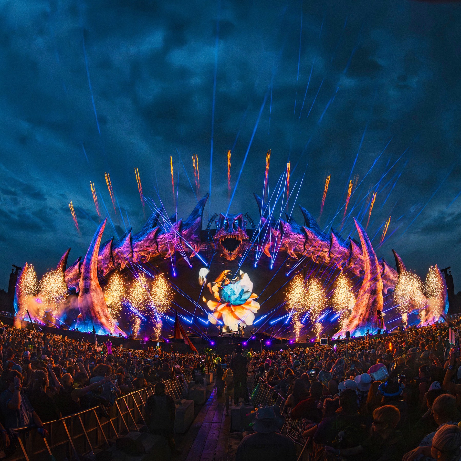 Festival main stage washed in lasers over a packed crowd